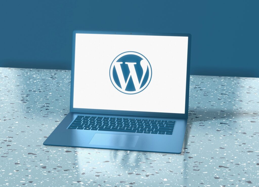 Ordinateur affichant le logo WordPress sur un bureau moderne
